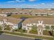 An aerial view of attractive townhomes, showcasing their tiled roofs, landscaping, and a tranquil pond feature at 4918 Windermere Ave, Kissimmee, FL 34746