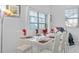 Bright dining room with white table set for six, features modern decor, creating an inviting space at 4918 Windermere Ave, Kissimmee, FL 34746