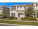 Charming two-story townhouse featuring a well-manicured lawn and a welcoming arched entryway at 4918 Windermere Ave, Kissimmee, FL 34746