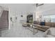 Bright, open-concept living room with modern tile flooring, contemporary furnishings and adjacent kitchen at 4918 Windermere Ave, Kissimmee, FL 34746