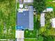 Aerial view of a home with a dark roof, green lawn, patio area, and several outbuildings at 5050 Howison Rd, Kissimmee, FL 34746