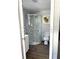 Bathroom featuring glass enclosed shower, toilet, wood floors, and white painted walls at 5050 Howison Rd, Kissimmee, FL 34746