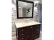 Bathroom vanity with dark wood cabinets, light countertop, decorative mirror and stone accent wall at 5050 Howison Rd, Kissimmee, FL 34746