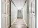 Hallway with light hardwood flooring and multiple white doors and access to outdoor area at 5050 Howison Rd, Kissimmee, FL 34746