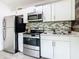Well-lit kitchen featuring modern stainless steel appliances and sleek white cabinets, perfect for culinary enthusiasts at 5050 Howison Rd, Kissimmee, FL 34746