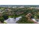 Aerial view of the apartment complex surrounded by trees, with a view of the pond and a glimpse of the city at 5283 Images Cir # 308, Kissimmee, FL 34746