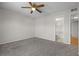 Bedroom with neutral walls and ceilings, a ceiling fan, and an en-suite bathroom for added privacy at 5283 Images Cir # 308, Kissimmee, FL 34746