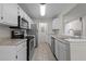 Functional kitchen boasts stainless steel appliances, white cabinets, and durable tile flooring at 5283 Images Cir # 308, Kissimmee, FL 34746