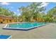 Community pool with blue accents surrounded by mature landscaping, perfect for a refreshing swim at 5283 Images Cir # 308, Kissimmee, FL 34746
