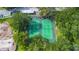 Top-down aerial view of community tennis courts surrounded by lush trees and nearby parking at 5283 Images Cir # 308, Kissimmee, FL 34746