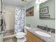 Bathroom with a granite-topped vanity and updated shower with patterned curtain at 5301 S Atlantic Ave # 51, New Smyrna Beach, FL 32169