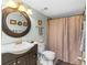 Well-maintained bathroom with decorative mirror and shower with curtain at 5301 S Atlantic Ave # 51, New Smyrna Beach, FL 32169