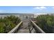 Gated beach access leads to the ocean, surrounded by lush greenery at 5301 S Atlantic Ave # 51, New Smyrna Beach, FL 32169