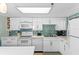 Bright kitchen featuring white cabinets, stainless steel appliances, and mosaic backsplash at 5301 S Atlantic Ave # 51, New Smyrna Beach, FL 32169