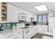 Well-lit kitchen with white appliances, modern cabinetry, and mosaic backsplash at 5301 S Atlantic Ave # 51, New Smyrna Beach, FL 32169