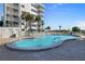 Resort-style pool area with lounge chairs and manicured landscaping with condo in the background at 5301 S Atlantic Ave # 51, New Smyrna Beach, FL 32169