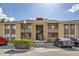 Condo exterior shows the building facade, parking and landscaping under a bright, sunny sky at 5321 Vineland Rd # 101, Orlando, FL 32811