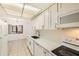 This is a bright kitchen with a white refrigerator, modern countertops, and stainless steel appliances at 5321 Vineland Rd # 101, Orlando, FL 32811