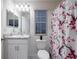Bright bathroom with a modern vanity and a decorative floral shower curtain at 555 Meadow Bend Dr, Davenport, FL 33837