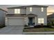 Charming two-story home with a manicured front yard and attached two-car garage at 555 Meadow Bend Dr, Davenport, FL 33837