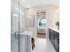 Modern bathroom with a glass-enclosed shower, soaking tub, double vanity, and a doorway to the primary bedroom at 5615 Wood Bridge Pl, St Cloud, FL 34771