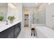 Bright bathroom featuring double sink vanity with black cabinets, a walk-in shower and a soaking tub at 5615 Wood Bridge Pl, St Cloud, FL 34771