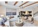 Spacious living room with wooden beam ceilings and open floor plan that extends to a modern, dark-colored kitchen at 5615 Wood Bridge Pl, St Cloud, FL 34771