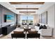 Bright living room with wooden beam ceilings, gray accent wall, a modern chandelier, and a view to the outdoors at 5615 Wood Bridge Pl, St Cloud, FL 34771
