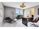 Modern office with a unique desk, rocking lounge chair, and industrial-style lighting fixture at 5615 Wood Bridge Pl, St Cloud, FL 34771