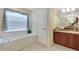 Well-lit bathroom featuring vanity with tub and tiled flooring, offering functionality and style at 609 Westview Dr, Minneola, FL 34715