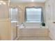 Bright bathroom features a tiled tub with a shower, providing a clean and relaxing space at 609 Westview Dr, Minneola, FL 34715