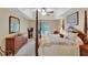 Airy main bedroom with a four-poster bed, balcony access, and a glimpse of outdoor scenery at 609 Westview Dr, Minneola, FL 34715