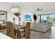 Open-concept living area with beach view, plush seating, capiz chandelier, and unique coastal decor at 7 Marden Dr, Ormond Beach, FL 32176