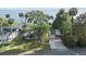 Aerial view of waterfront home featuring a well-manicured lawn, mature trees, and stunning water access at 7046 Treasure Island Rd, Leesburg, FL 34788