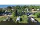 Aerial view showcasing waterfront homes and private docks along a serene lake, surrounded by lush greenery at 7046 Treasure Island Rd, Leesburg, FL 34788