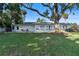 Expansive backyard with mature trees and a sunroom, perfect for outdoor relaxation at 7046 Treasure Island Rd, Leesburg, FL 34788