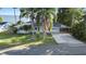 Well-maintained home with palm trees and a large driveway located on a waterfront property at 7046 Treasure Island Rd, Leesburg, FL 34788