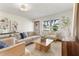 Bright living room featuring neutral tones, modern decor, and large windows offering picturesque neighborhood views at 7046 Treasure Island Rd, Leesburg, FL 34788