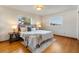 Bright main bedroom with hardwood floors, a cozy rug, and large windows providing peaceful views at 7046 Treasure Island Rd, Leesburg, FL 34788