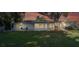 Home exterior featuring a large backyard with mature trees and a spacious sunroom at 7046 Treasure Island Rd, Leesburg, FL 34788