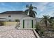 View of the backyard with a shed, brick patio, and tropical landscaping creating a private outdoor space at 7407 Country Run Pkwy, Orlando, FL 32818