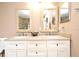 Bathroom featuring double vanity sinks with granite countertops and decorative mirrors at 7407 Country Run Pkwy, Orlando, FL 32818