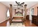 Elegant bedroom featuring a four-poster bed, hardwood floors, and a ceiling fan at 7407 Country Run Pkwy, Orlando, FL 32818