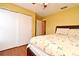 Comfortable bedroom with a large closet, connecting bathroom, and queen bed set on dark wood floors at 7407 Country Run Pkwy, Orlando, FL 32818