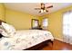 Bedroom with hardwood floors, ceiling fan, natural light, and yellow walls provides a bright and welcoming space at 7407 Country Run Pkwy, Orlando, FL 32818