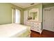 Bright bedroom featuring a large dresser with mirror, hardwood floors and a pastel green color scheme at 7407 Country Run Pkwy, Orlando, FL 32818