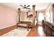 Elegant bedroom with a four-poster bed, hardwood floors, and a ceiling fan at 7407 Country Run Pkwy, Orlando, FL 32818