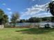 Expansive backyard overlooking a serene lake with mature trees and a private dock at 7508 Lake Marsha Dr, Orlando, FL 32819
