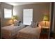 Cozy bedroom featuring two beds, accent pillows, bedside tables with lamps, and natural light at 7508 Lake Marsha Dr, Orlando, FL 32819