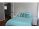 Comfortable bedroom with aqua colored bedding, a white bedside table, and natural light at 7508 Lake Marsha Dr, Orlando, FL 32819